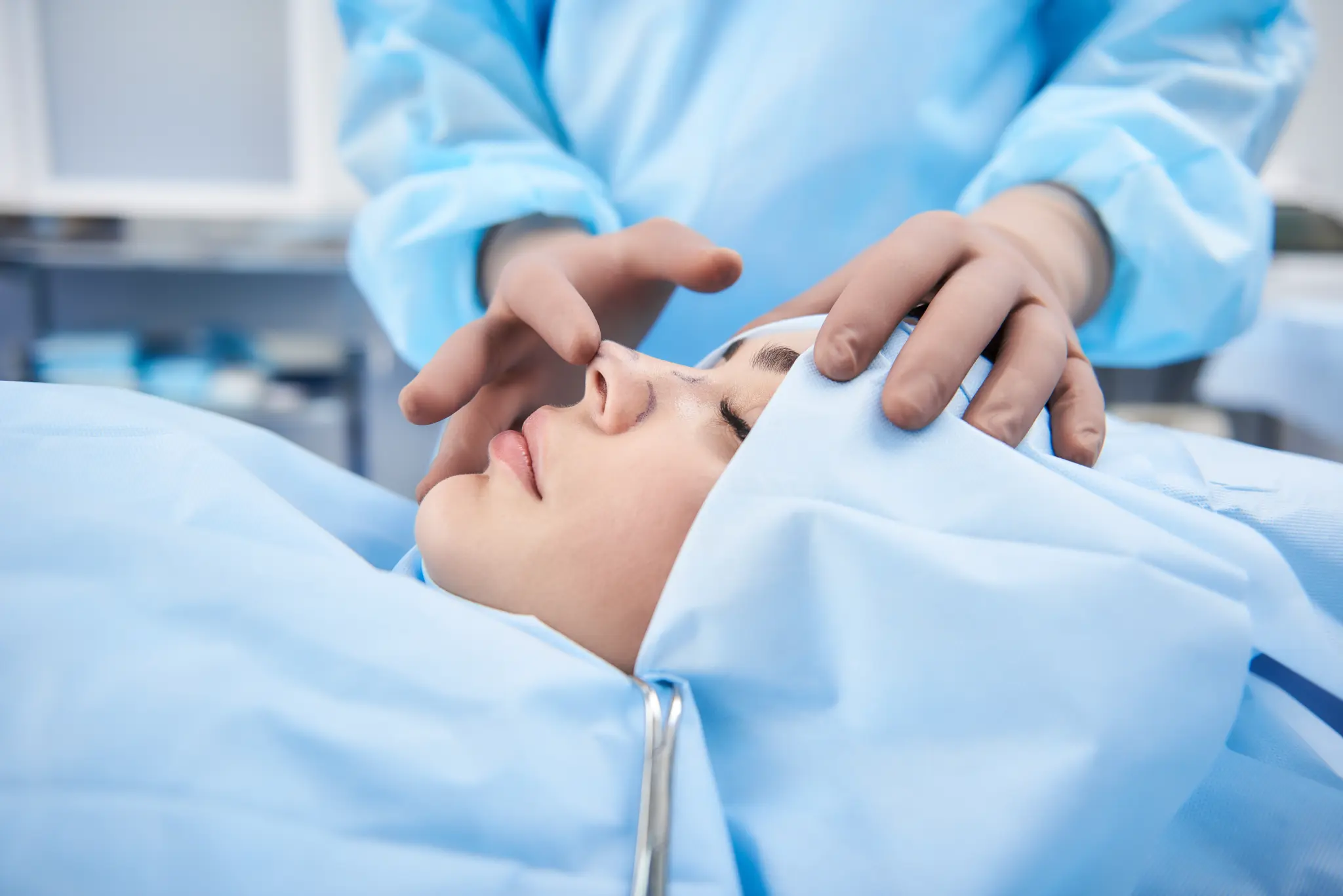 Cirujano evaluando nariz de paciente en quirófano - rinoplastia cerrada